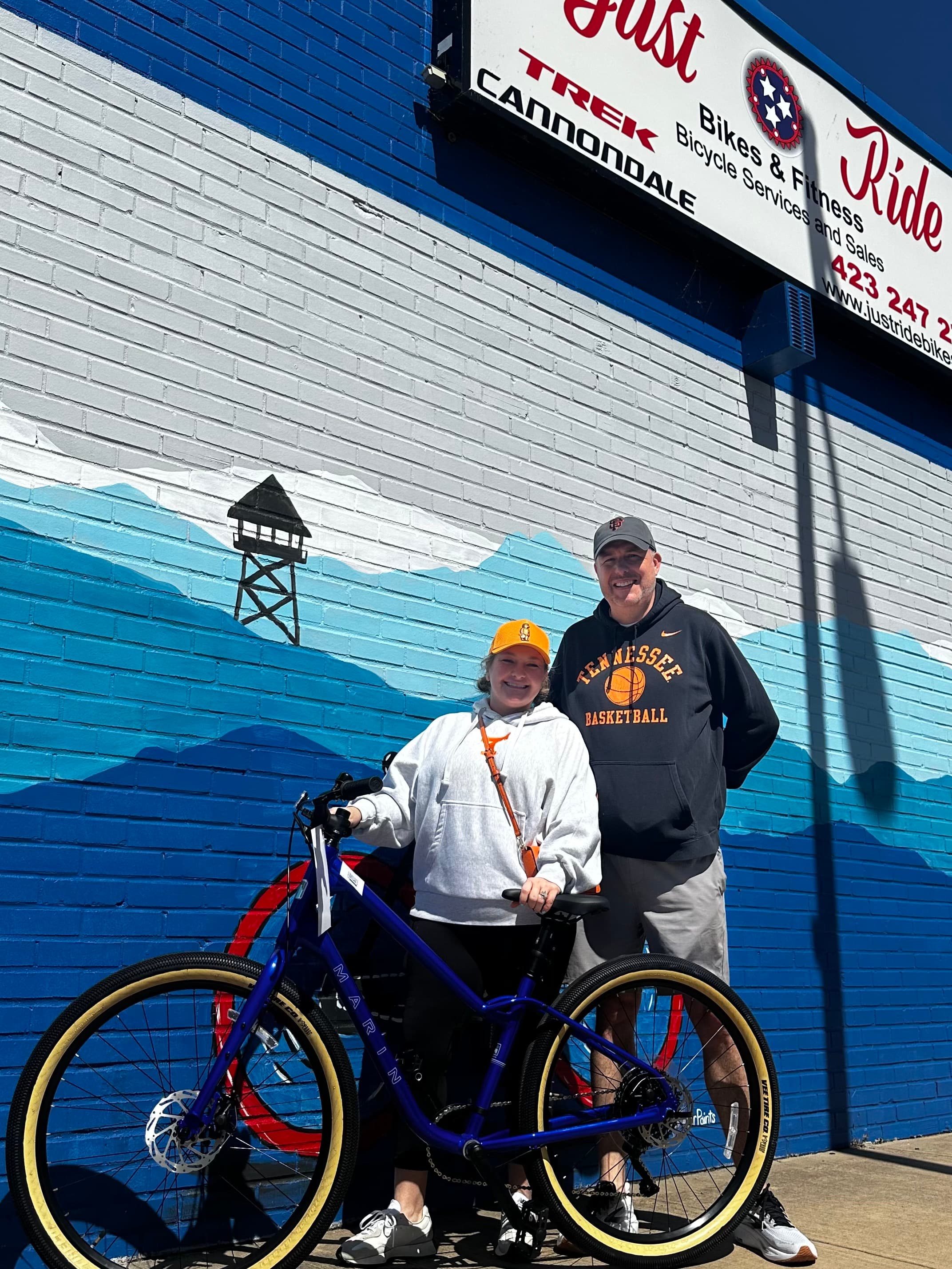 A Just Ride customer with their new bike outside the shop