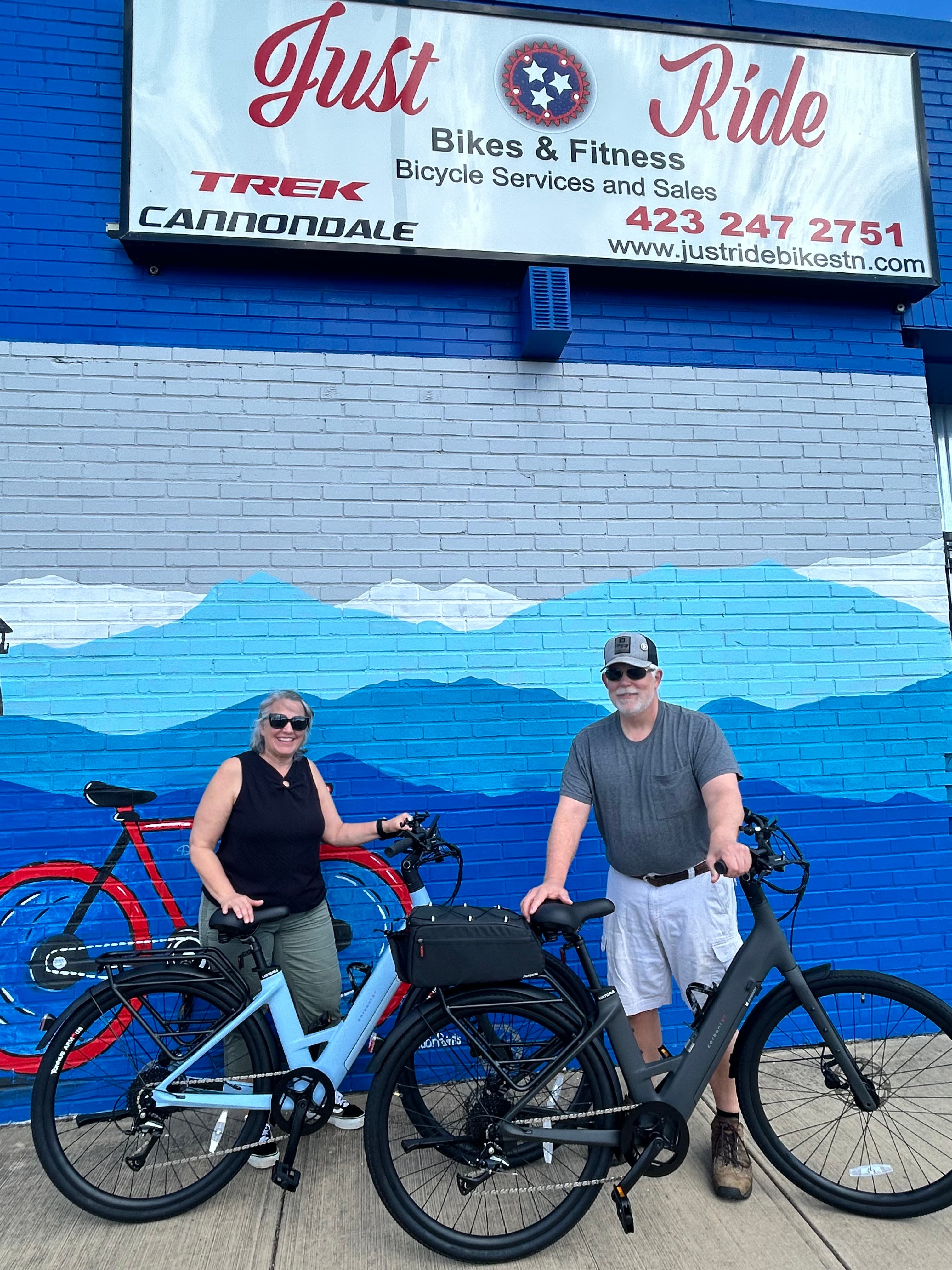 A Just Ride customer with their new bike outside the shop