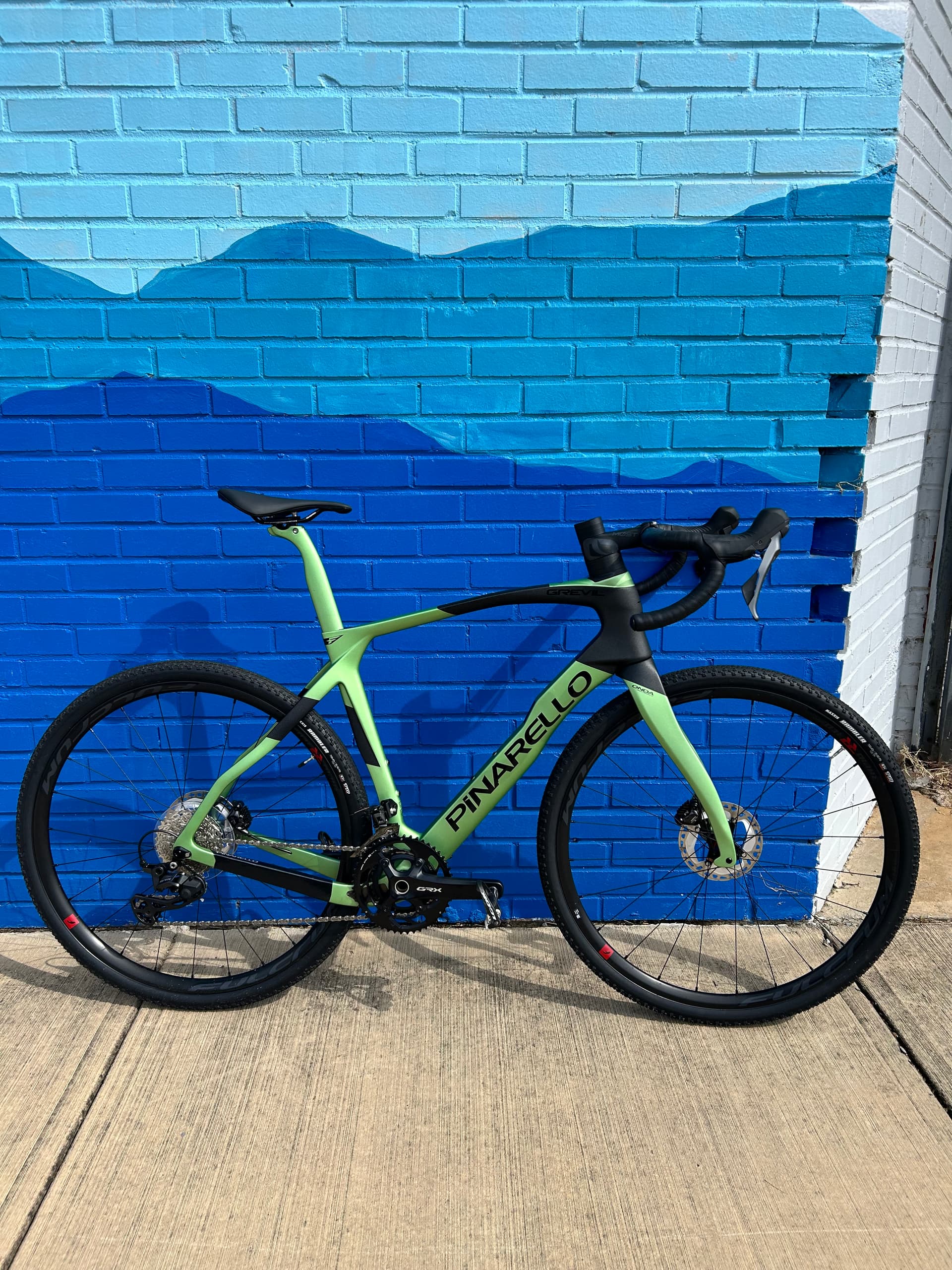 Pinarello Grevil gravel bike against a blue brick wall