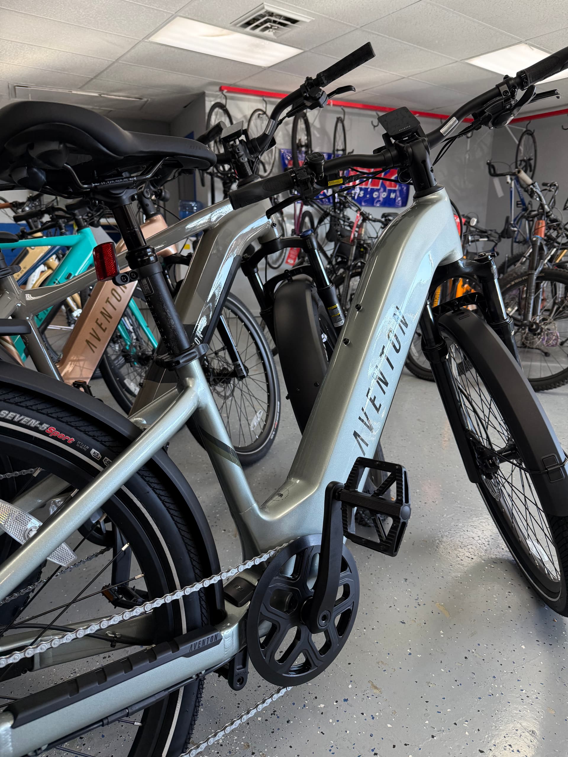 Aventon e-bikes lined up on the floor at Just Ride